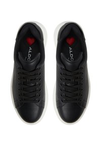 Černé kožené sneakersy mají bílou gumovou podrážku, kulatou špičku a černé tkaničky. Uvnitř je malý detail červeného srdíčka. Viditelné logo značky.