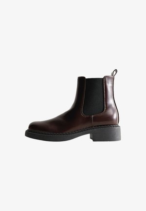 Brown leather ankle boot with elastic side panels, round toe, and a textured black rubber sole. Features contrasting stitching and a pull tab.