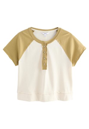 Kurzarm-Cropped-Top mit einem kremfarbenen Körper und olivgrünen Raglanärmeln, versehen mit einer Knopfleiste und einem gewellten Saum.