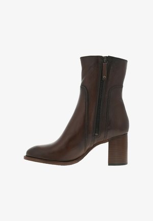 Bottines en cuir marron avec une fermeture éclair sur le côté, bout arrondi et talon en bois empilé. Texture lisse avec des détails de couture discrets.