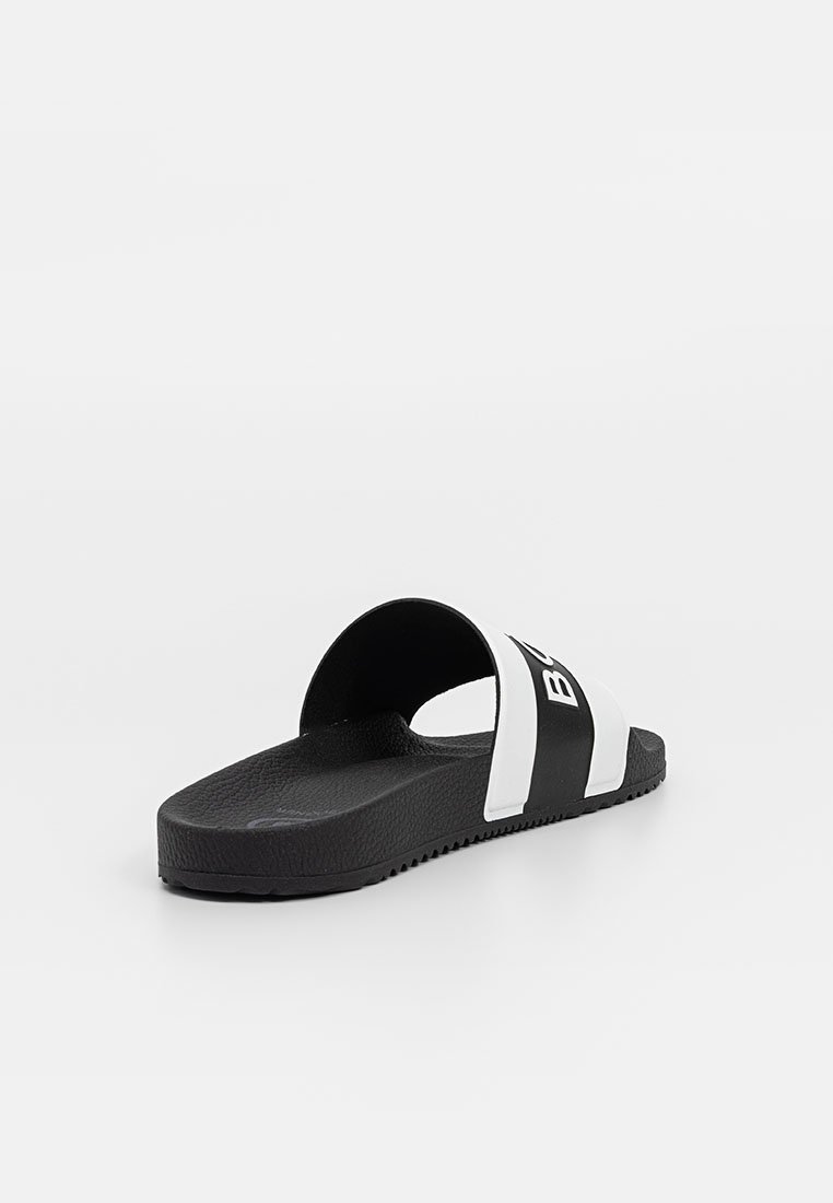 Schwarz-weiße Rutschsandale mit einer strukturierten Fußbett und einem breiten Riemen oben, der auffälligen weißen Text auf schwarzem Hintergrund trägt.