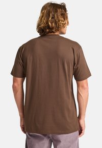 Brun kortærmet t-shirt lavet af bomuld, med en rund halsudskæring og en glat overflade. Bagfra ses en afslappet pasform.