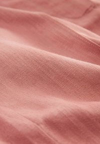 Jasnoróżowa tkanina o miękkiej fakturze i delikatnym połysku, prezentująca gładką powierzchnię i drobny wzór splotu.