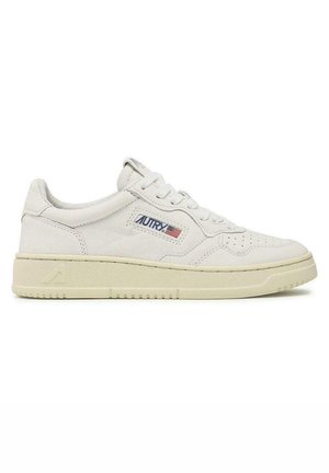 Sneaker in pelle bianca con superficie testurizzata, caratterizzata da un profilo basso, punta rotonda, dettagli perforati e una suola beige a contrasto.