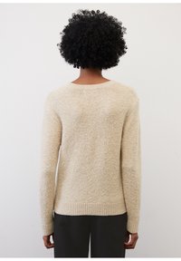 Pull en tricot beige texturé avec un encolure ronde et des manches longues, présentant un ourlet et des poignets côtelés, vu de dos.