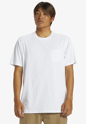 Vit bomulls t-shirt med rund halsringning och korta ärmar. Har en liten ficka på vänster sida. Mjuk textur, avslappnad passform.
