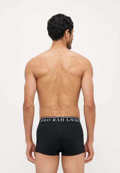 Black boxer briefs with a wide waistband featuring white "POLO RAH LAUREN" lettering. Smooth fabric on a male model's back, no visible patterns.