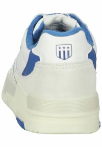 Weißer Sneaker mit blauen Akzenten, Wildleder-Ferse, strukturiertem Gummisohle und einem Logo mit drei Sternen auf der Rückseite.