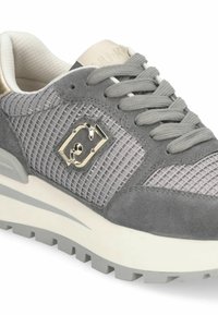 Sneaker grigia in suede e mesh con un design testurizzato, dettaglio del logo metallico e suola bianca chunky con battistrada a motivo.