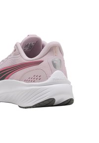 Scarpa sportiva rosa chiaro con tomaia in rete, accenti neri e rosa, suola bianca imbottita e dettaglio riflettente sul tallone.