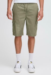 Shorts cargo en verde oliva con cintura ajustable, bolsillos laterales y un corte relajado. Fabricados en un tejido ligero y texturizado.