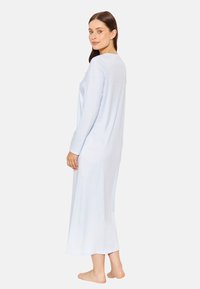 Hellblaues langes Nachthemd aus weichem Stoff, mit langen Ärmeln, rundem Ausschnitt und einer lockeren Silhouette, die unter die Waden reicht.