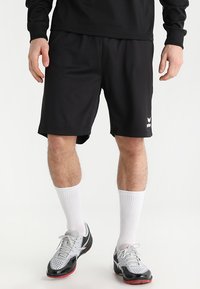 Schwarze Sportshorts aus leichtem Material, mit bequemer Passform und einem weißen Logo-Detail auf der unteren linken Seite.