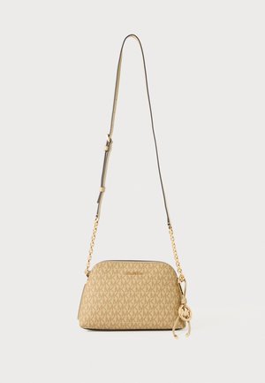 Sac bandoulière beige Michael Kors avec logo MK répétitif, bandoulière réglable en cuir et chaîne dorée, et pendentif rond MK sur le côté.