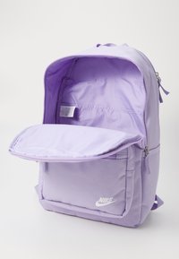 Μωβ σακίδιο Nike με υφαντή εξωτερική επιφάνεια, μπροστινή τσέπη και κυρίως θήκη με φερμουάρ. Ο εσωτερικός υφασμάτινος φινιρίσματος είναι επίσης μωβ.