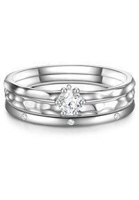 Ezüst gyűrű, központi kerek gyémánttal és kisebb kísérő kövekkel. Sima gyűrűpánttal és kontrasztos, texturált részletekkel rendelkezik.