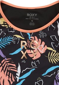 Čierne plavky s tropickými kvetinovými vzormi v pastelových farbách, svetloružovým golierom a kovovo zlatým logom "ROXY" na prednej strane.
