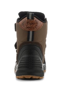 Brun vandringskänga med en strukturerad tygövre, svart gummisula och förstärkt häl. Har grå accentränder och en robust design.