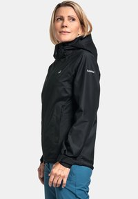 Schwarze wasserdichte Jacke mit Kapuze, Reißverschluss und Seitentaschen. Verfügt über ein tailliertes Design und ein Logo auf dem linken Ärmel.