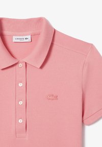 Roza polo majica iz teksturiranega materiala s slim fit krojem, ima ovratnik, gumbasti zapnalo in vezeno logo na levi prsni strani.
