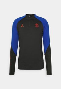 Langärmliges schwarzes Sportoberteil mit blauen Ärmeln, Viertelreißverschluss, rotem Paris Saint-Germain- und Jordan-Brand-Logo auf der Brust.