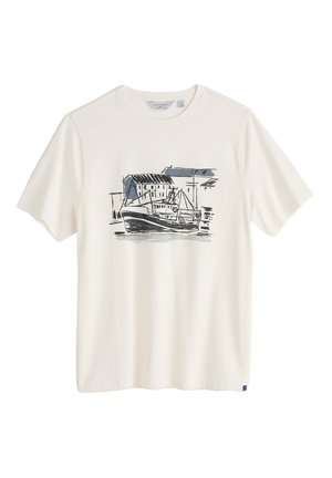 T-shirt di cotone color crema con una grafica di una barca da pesca e darsena in inchiostro blu e nero. Maniche corte e scollatura rotonda.