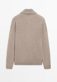 Pull en maille beige à manches longues avec col plié, vu de dos sur un fond blanc uni.