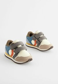 Baskets Velcro en bleu, crème et gris. Caractéristiques : une tige en maille, des accents en daim et une semelle en caoutchouc avec une bande jaune.