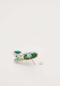 Green and iridescent gem brooch with gold-tone metal, flower design, and pin backing. Includes an additional fastening loop.