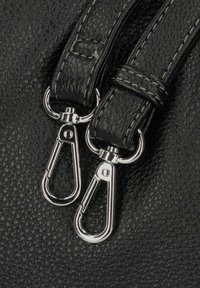 Borsa in pelle nera con texture, dotata di due clip metalliche argentate. Le cuciture sono visibili, mettendo in risalto i dettagli del design sulle cinghie.