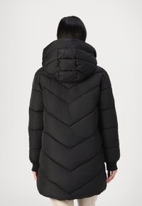 Manteau d'hiver noir en duvet avec un motif matelassé en chevron, capuche réglable et poignets côtelés. Tissu léger avec une texture lisse.
