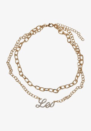 Aranyszínű, dupla láncú nyaklánc, amelyet díszített "Leo" medál ékesít, csillogó kövekkel, ovális és kerek láncszemekkel összekapcsolva.