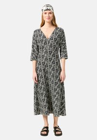 Schwarz-weißer Maxikleid mit Muster, tiefem V-Ausschnitt, 3/4-Ärmeln und lockerer Passform. Auffälliges Blätterdesign und fließende Stoffstruktur.