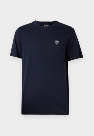 Camiseta de algodón azul marino con cuello redondo, mangas cortas y un pequeño logo de EA7 en el pecho, textura suave, diseño casual.