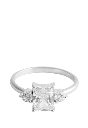 Silver ring with a large rectangular-cut clear gemstone in the center and smaller round clear gemstones on each side against a white background.