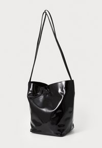 Bolso tote de charol negro con un diseño suave y arrugado. Cuenta con dos tirantes largos y delgados para el hombro y una apertura en la parte superior.