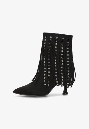 Bota de ante negra hasta el tobillo con punta afilada, detalles de flecos y acentos de ojales plateados. Presenta un tacón de altura media para un estilo elevado.