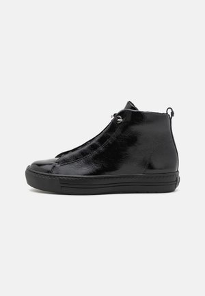 Bottines noires en cuir avec un design élégant, comportant des œillets métalliques, une finition texturée et une semelle en caoutchouc noir.