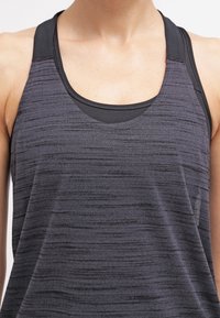 Mouwloos sporttopje in donkergrijs met een gestructureerd patroon, voorzien van een ronde hals en een gelaagde zwarte onderlaag voor extra ondersteuning.