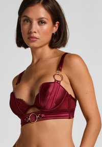 Bordeauxfarbener Satin-BH mit Spitzenbesatz, Bügelcups, breiten Trägern und goldfarbenen Beschlägen mit einem runden Akzent in der Mitte.