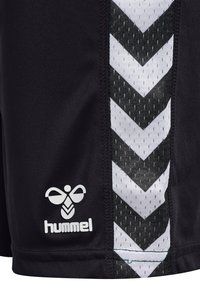 Svarta, sportiga shorts med ett vitt och svart zick-zackmönster på sidan, tillverkade av andningsbart tyg; logotyp tryckt i vitt.