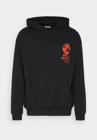 Sudadera negra con bolsillo canguro en la parte delantera, capucha con cordones y pequeño gráfico rojo con el texto "Artes y Sociedad" en el lado izquierdo del pecho.