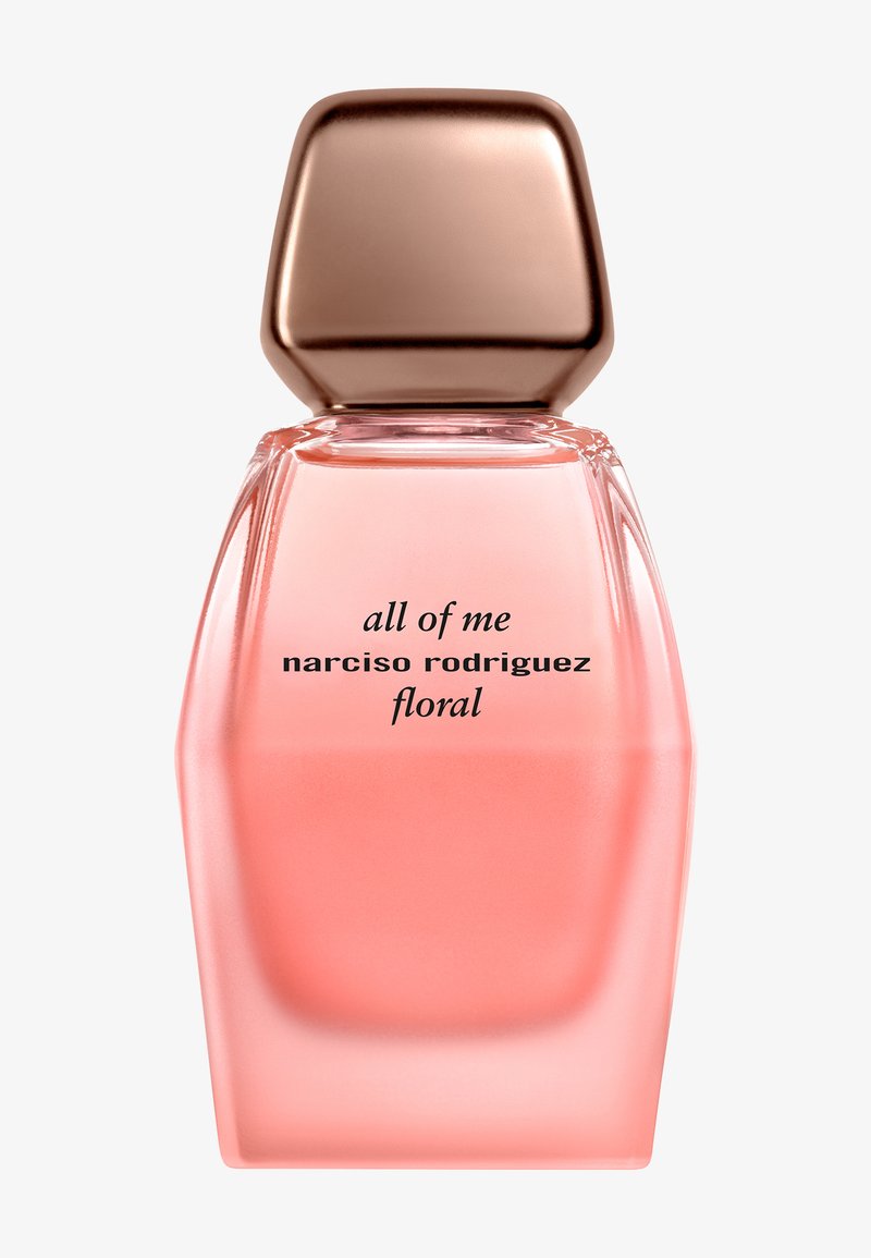 Bouteille de parfum en verre rose avec une forme géométrique et un capuchon métallique rose doré. L'étiquette indique "All of Me Narciso Rodriguez Floral."