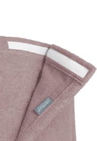Sanftes, helles Mauve-Handtuch mit einer strukturierten Oberfläche, ausgestattet mit einer weißen Aufhängeschlaufe und einem grauen Markentag, der in den Stoffrand genäht ist.