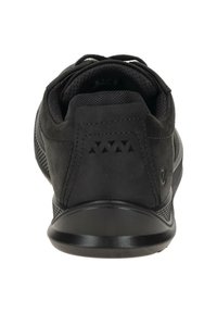Zwarte atletische schoen met een gestructureerde suède bovenkant, gaasaccenten, gevoerde kraag en een duurzame rubberen zool. Beschikt over driehoekige uitsparingen op de hiel.
