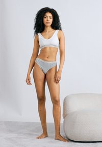 Λευκό αθλητικό σουτιέν με λεία υφή και φαρδιές τιράντες, σε συνδυασμό με γκρι βαμβακερές βραζιλιάνικες σλιπ με μαλακή μέση.