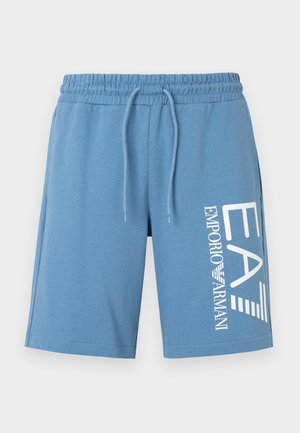 Calções azul-claro feitos de tecido macio, com cintura ajustável por cordão e um grande logótipo branco impresso no lado esquerdo.