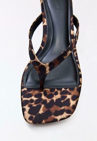 Damensandale mit schwarzem, gepolstertem Fußbett und braunen sowie schwarzen Riemen und Sohle mit Leopardenmuster, verfügt über ein Zehensteg-Design und eine eckige Zehenpartie.