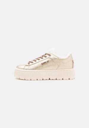 Niski sneaker na platformie z beżową fakturą krokodyla, brązowymi sznurowadłami, białą futerkową wyściółką i grubą białą podeszwą, widoczny z boku.