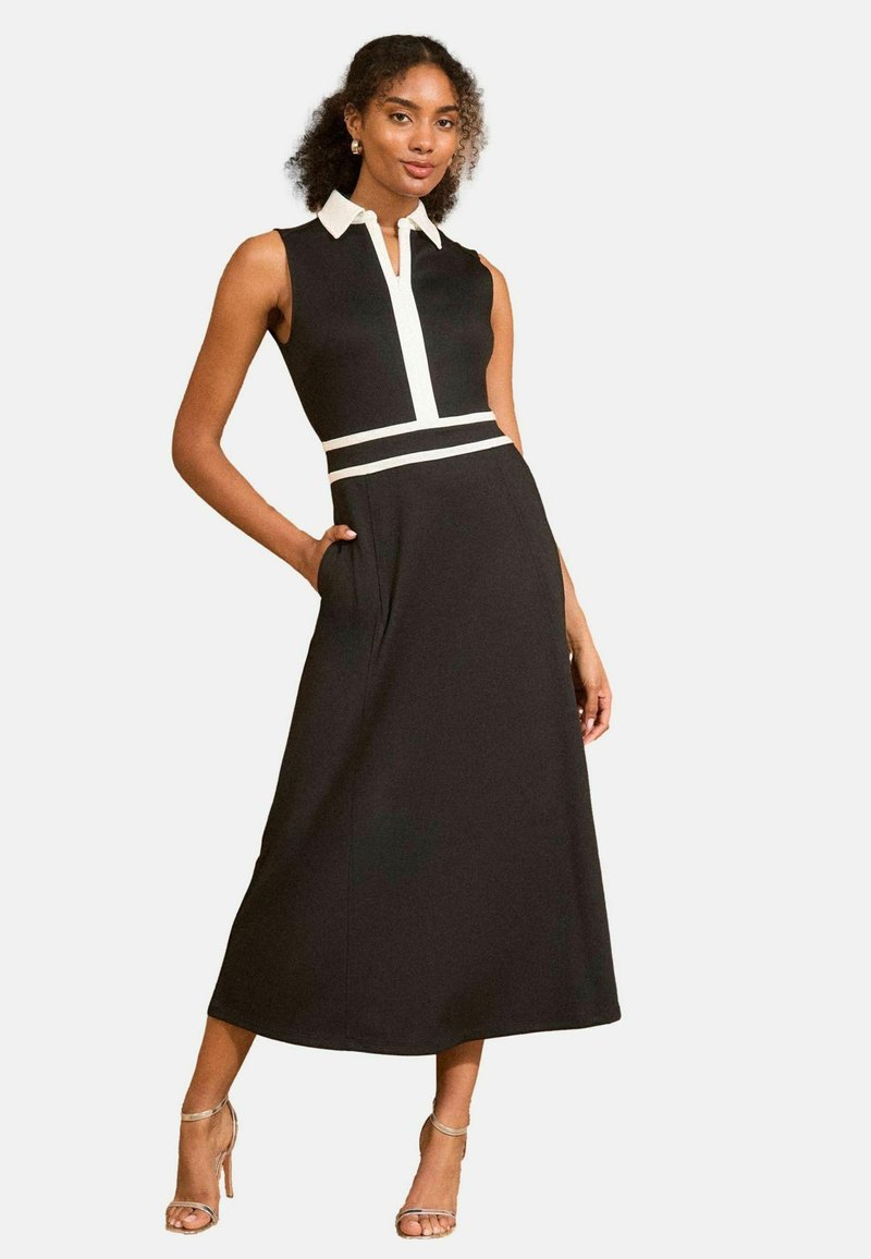 Must kulminaatidega kleit valge kraega ja külgtriipudega, millel on istuv bodice, A-line seelik ja küljetaskud. Sile kangas.